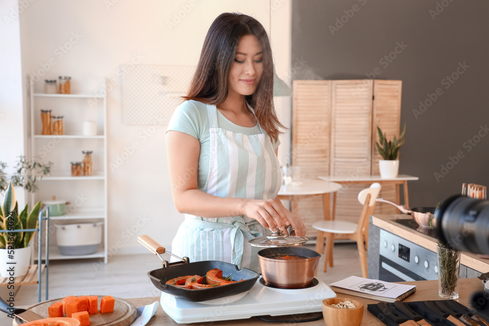 亚洲年轻女子在厨房录制视频课时煮南瓜