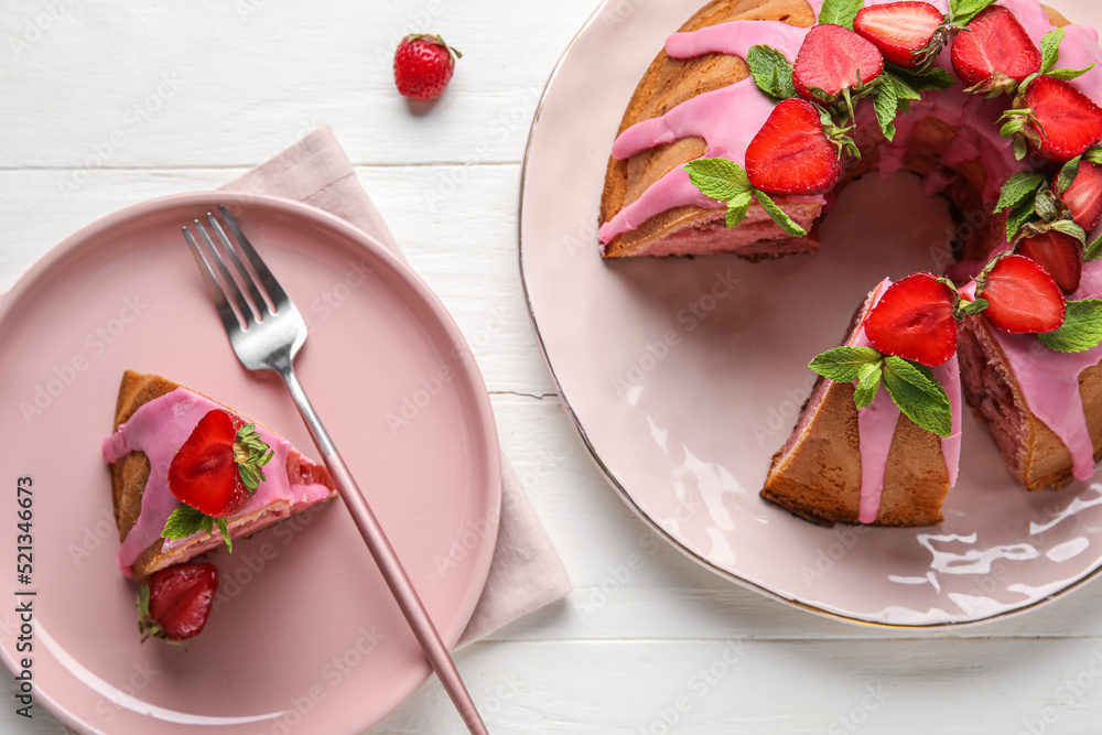 Composition with plates of tasty strawberry cake on light wooden background, closeup