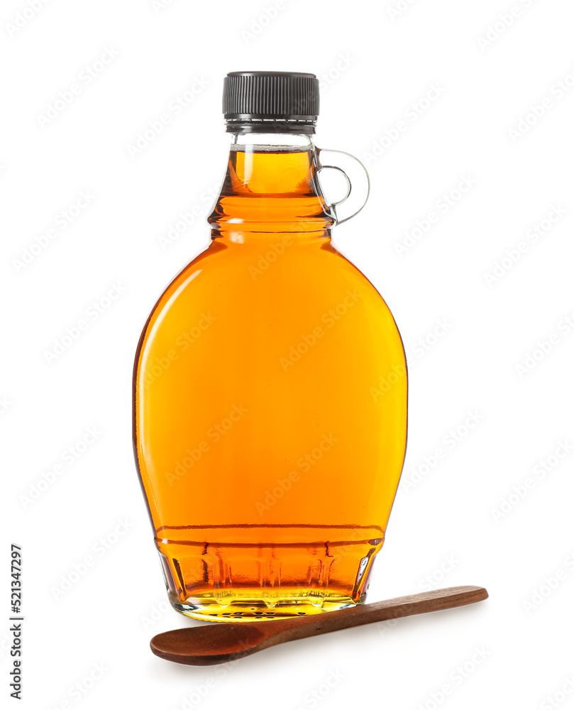 Bottle of maple syrup and wooden spoon on white background