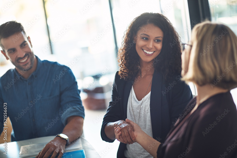 Handshake by businesswomen to congratulate in a meeting at work. Business professionals greet and ma