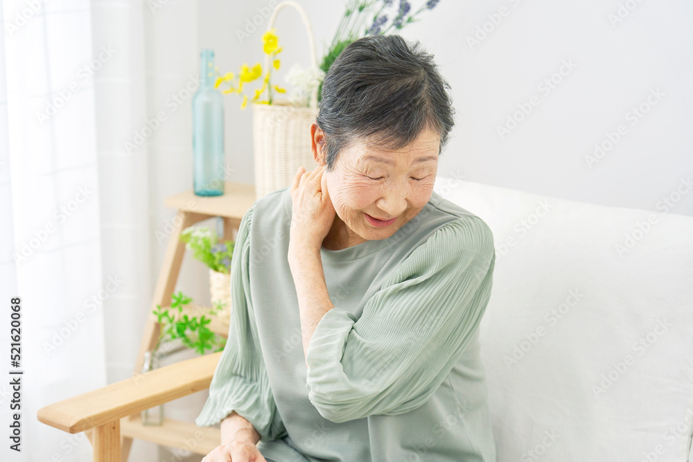 室内で肩こりを感じるシニア女性