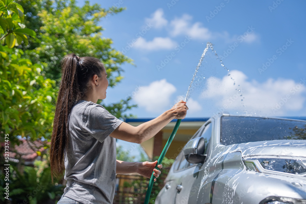 Women washing cars at home on vacation.