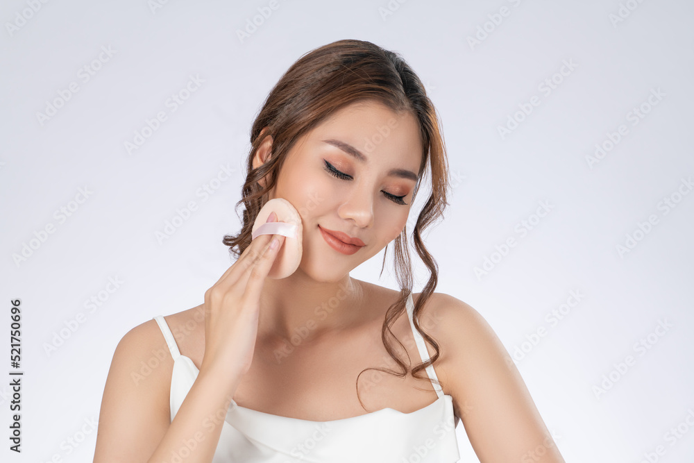 Face make up concept. Portrait of gorgeous young girl applying dry powder foundation. Beautiful mode