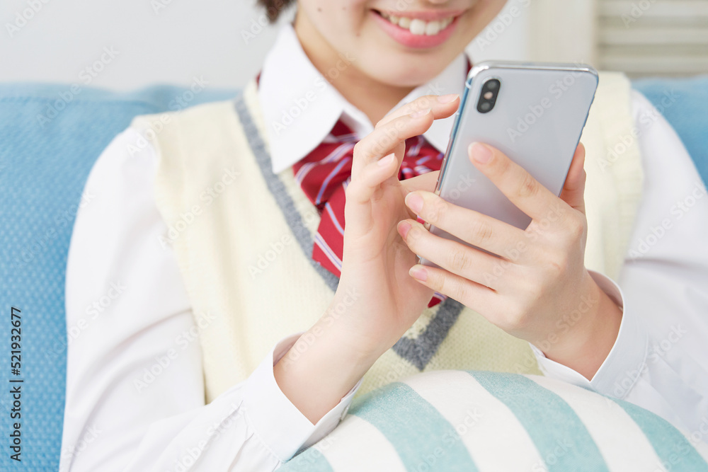 自宅でスマホを使う女子高生