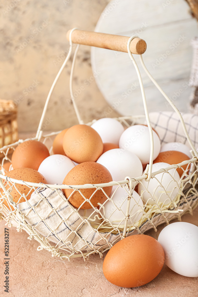 Basket with chicken eggs on beige table, closeup