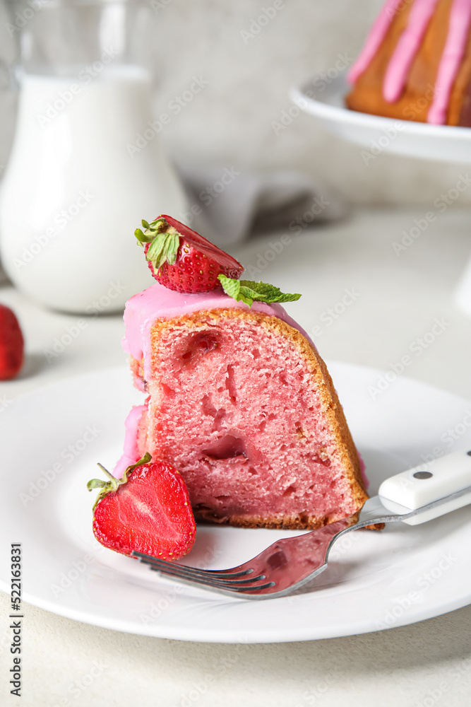 Plate with piece of strawberry cake on table, closeup