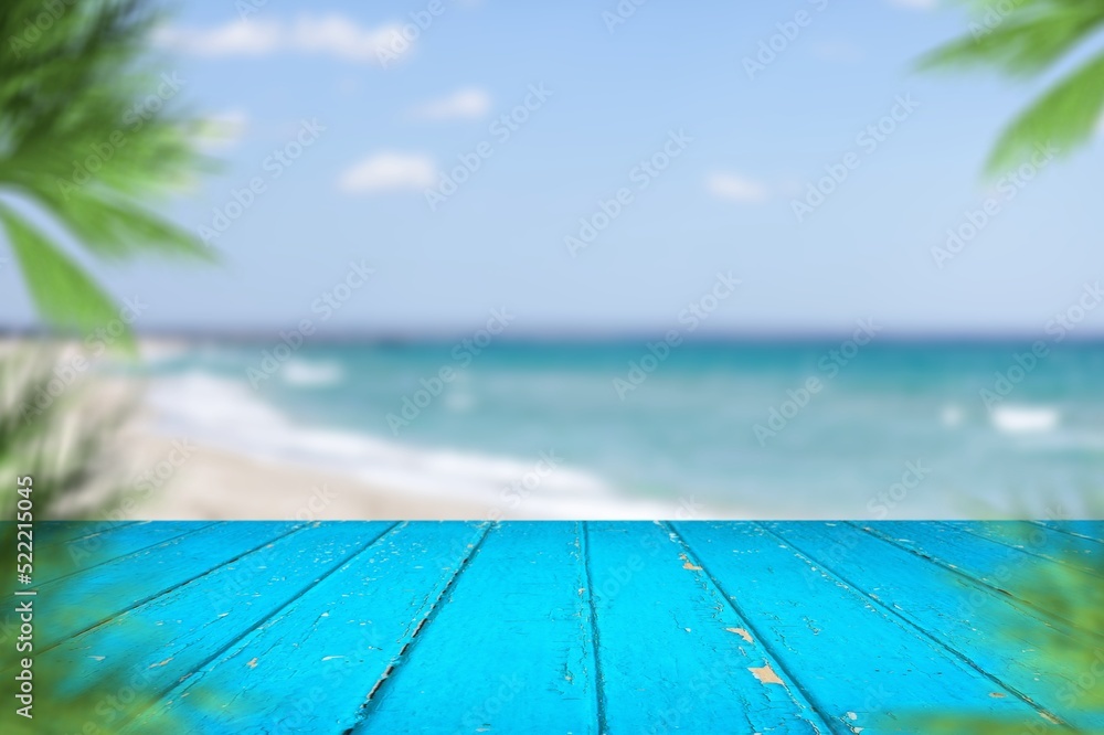 Blur tropical beach and palm tree with empty old wood table. Product presentation in nature.