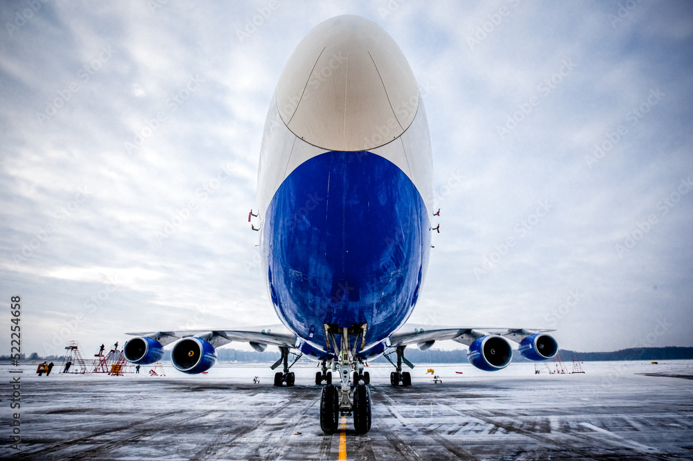 Airplane front fuselage with blue sky. Aircraft on runway of airfield