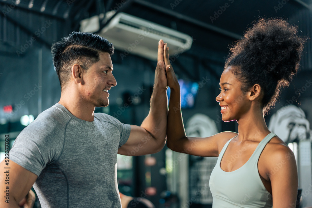 Caucasian Fitness trainer and young sportswoman exercise in fitness. 