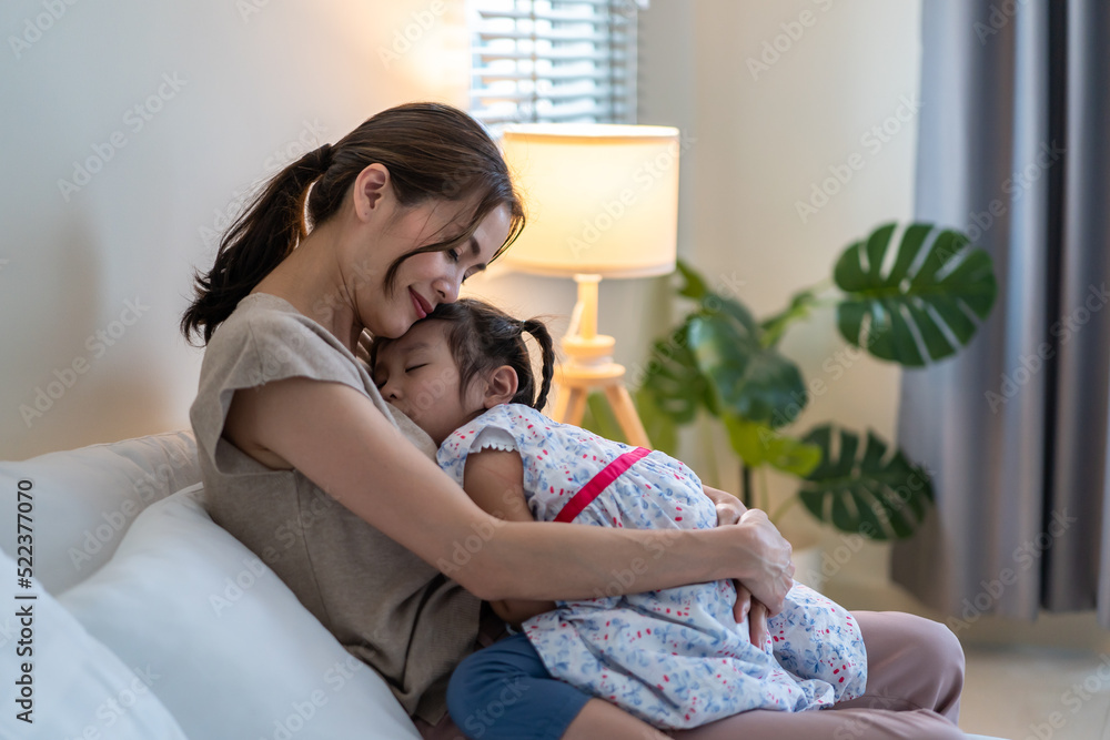 亚洲美女妈妈温柔地将熟睡的女婴抱在怀里。