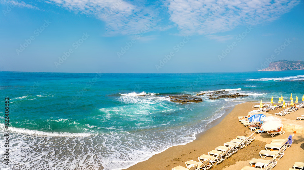 地中海沙滩上绿松石海浪与泡沫和岩石的美丽曲线