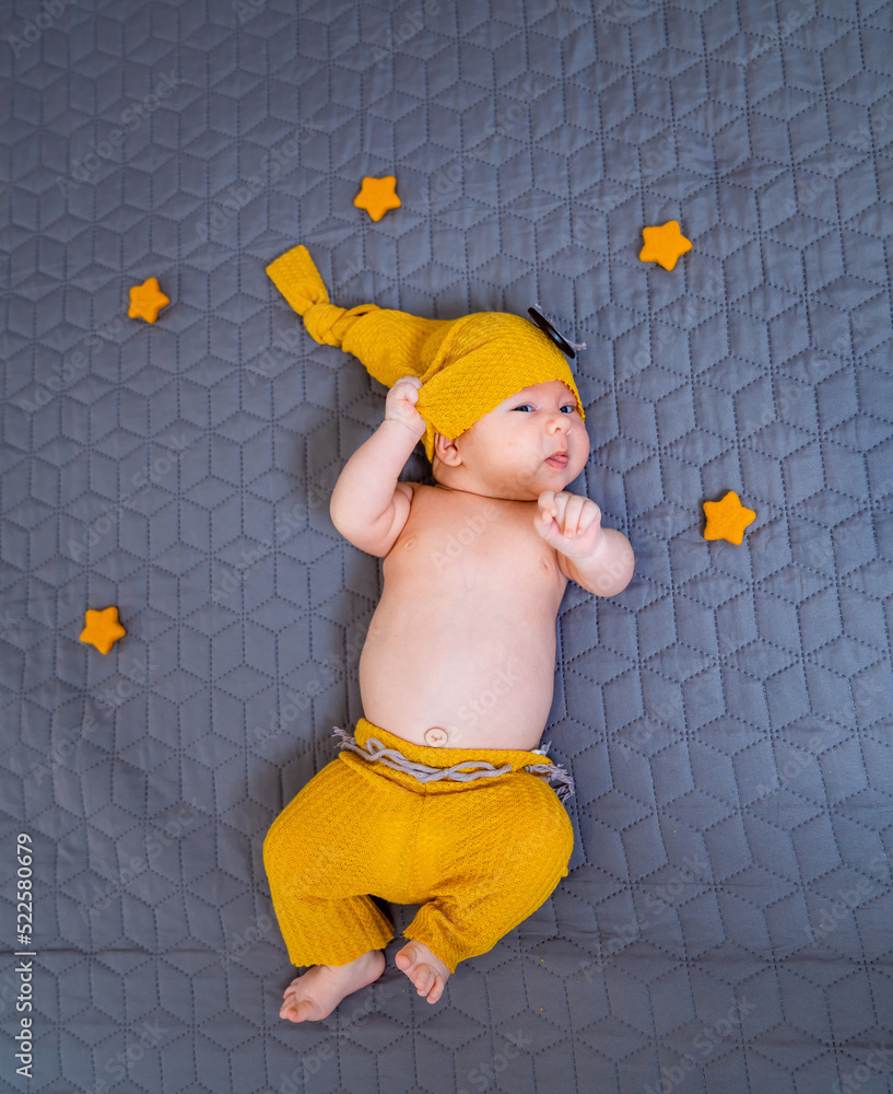 Sweet cute newborn baby lying on the blanket. Adorable small child in knitted hat.