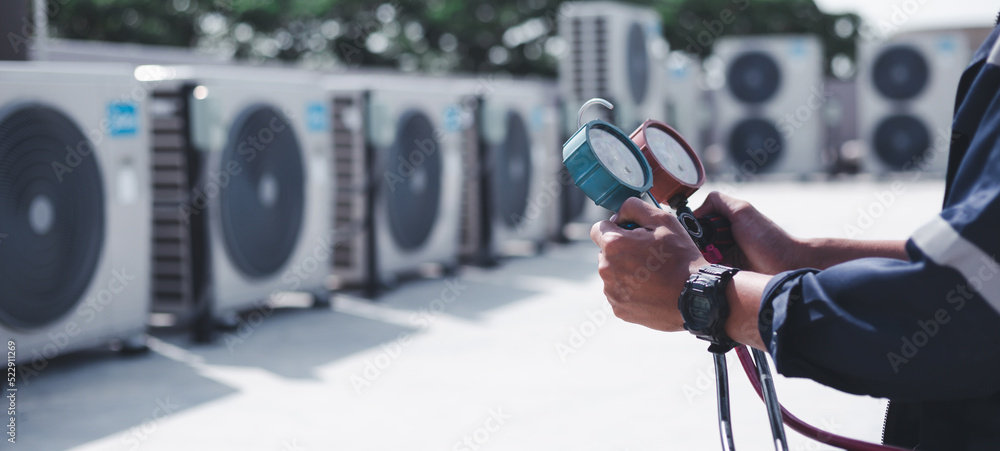 Technician is checking air conditioner ,measuring equipment for filling air conditioners.