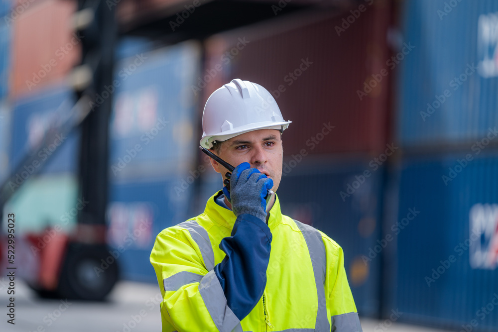 Technicians using walkie talkie checking stock for loading in the container yard warehouse,Logistic 