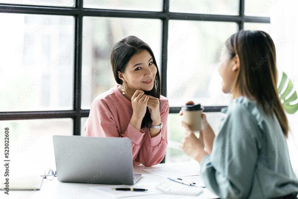 两位亚洲商务女性在会议室，两位美丽的商务女性开心而自信地微笑