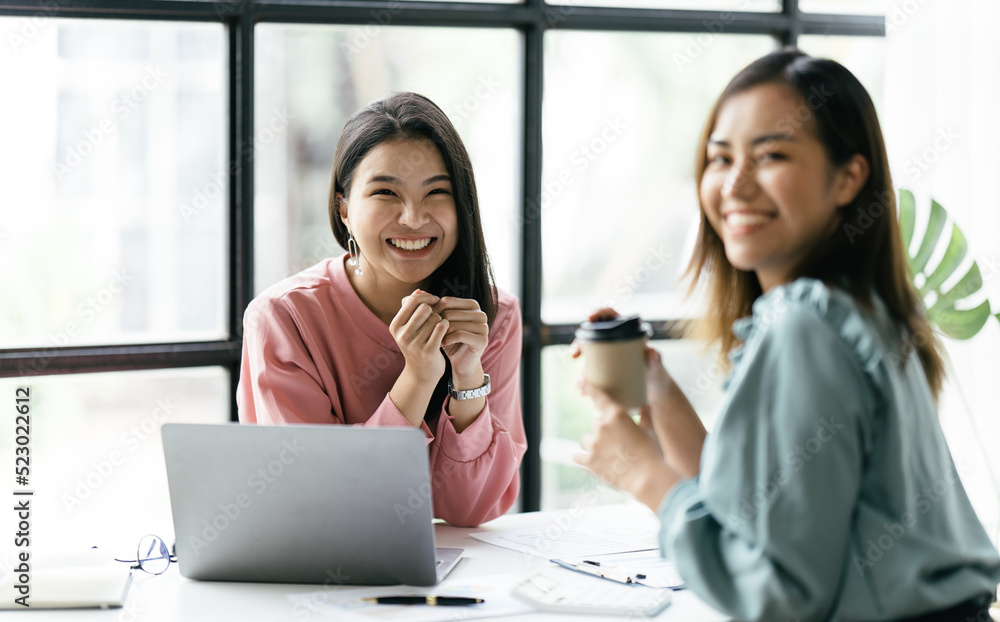 两位亚洲商务女性在会议室，两位美丽的商务女性开心而自信地微笑