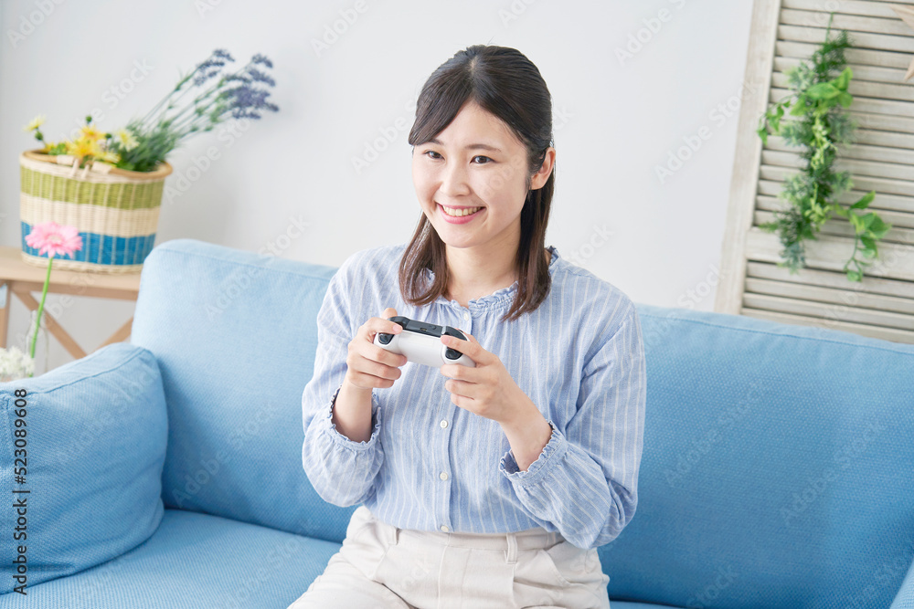 自宅で一人でテレビゲームをする女性