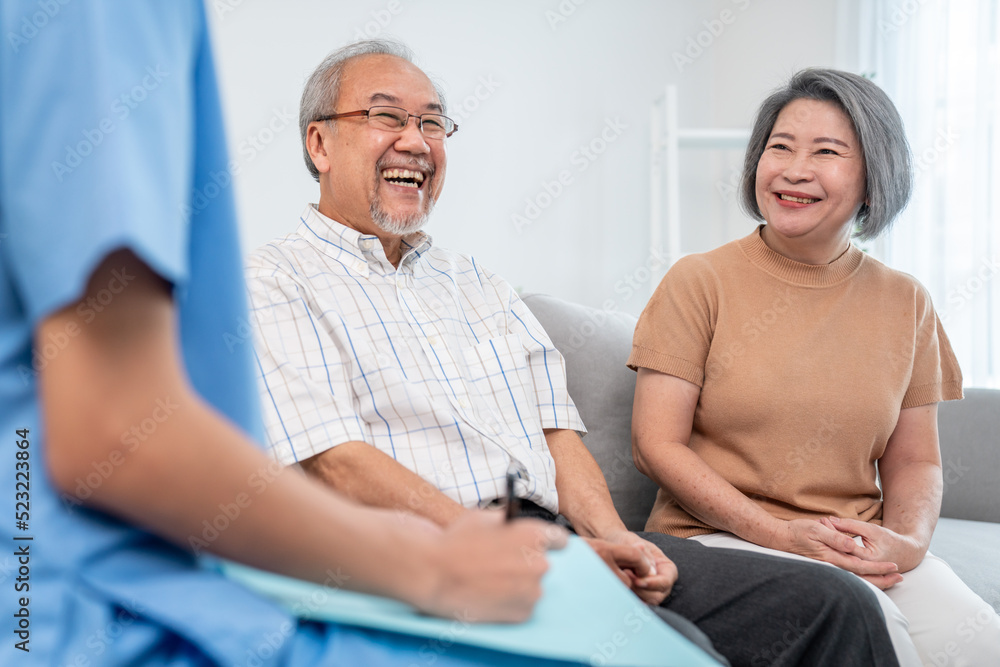 Female doctor visiting a contented elderly couple at their home. Health care, senior health support 