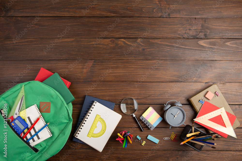 Back to school - books and school backpack on the desk in the auditorium, Education concept.