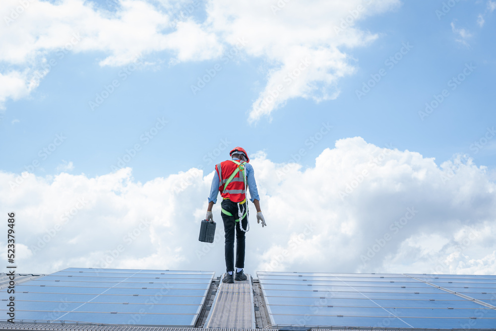 技术人员正在检查太阳能电池板，工程师正在检查f屋顶上安装的太阳能电池