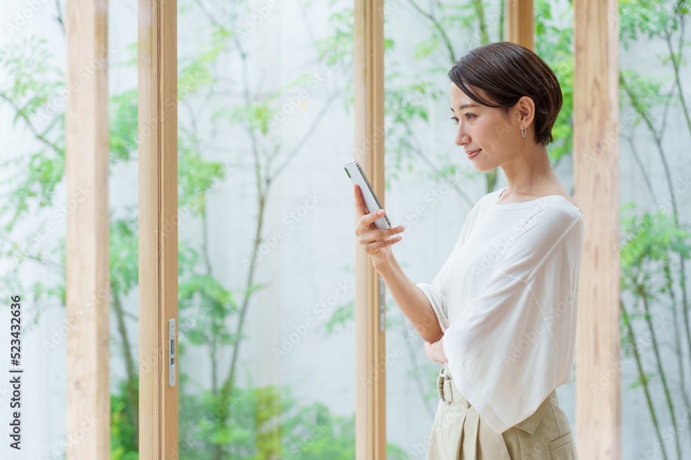 リビングでスマートフォンを使う若い女性