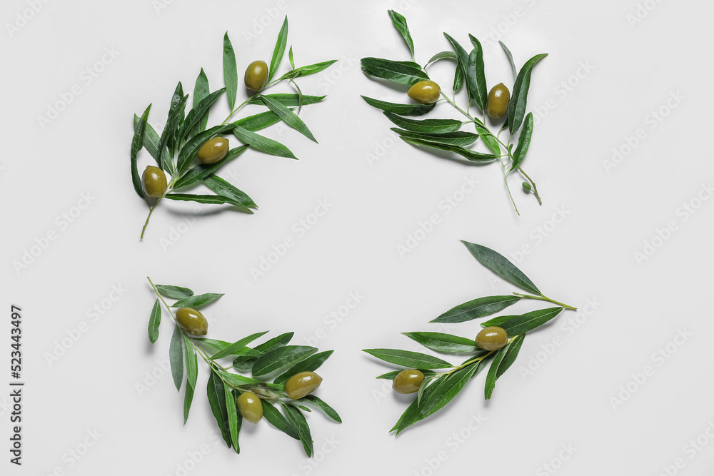 Frame made of green olives and leaves on white background