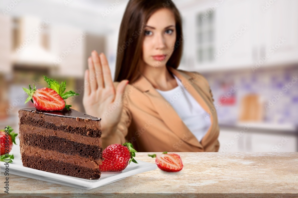 Young teenager girl refuses to eat cake. Say NO to unhealthy food, healthy eating and lose weight co