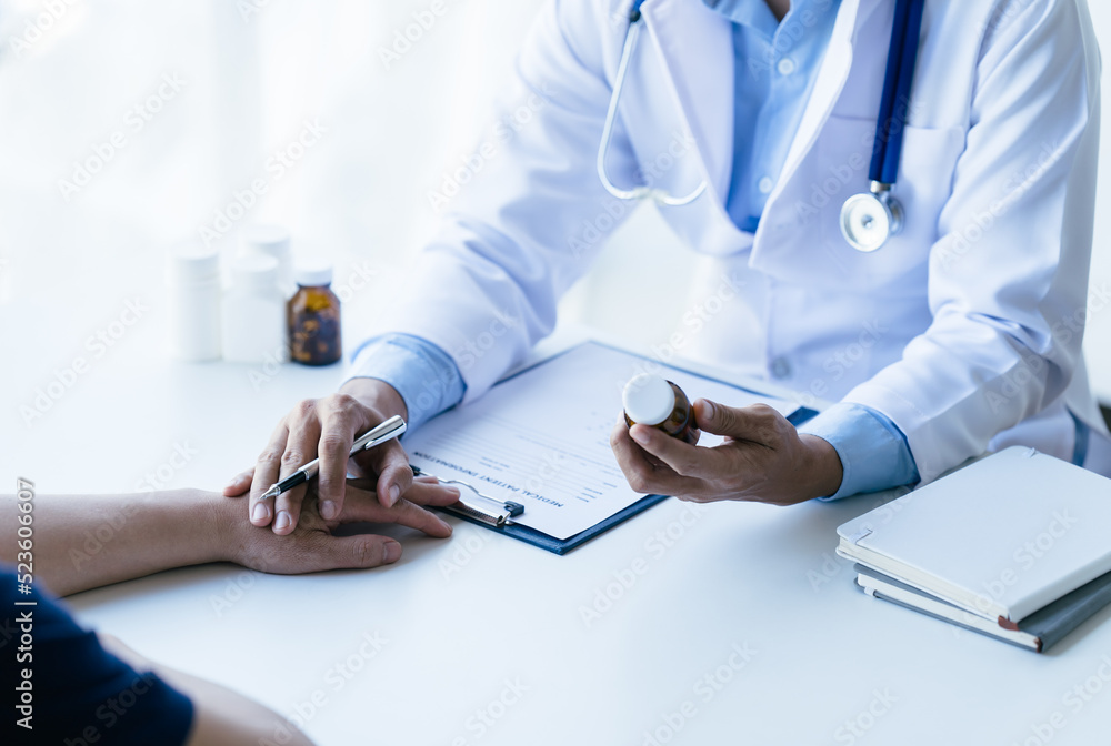 Doctor and patient sitting and talking at medical examination at hospital office, close-up. Therapis