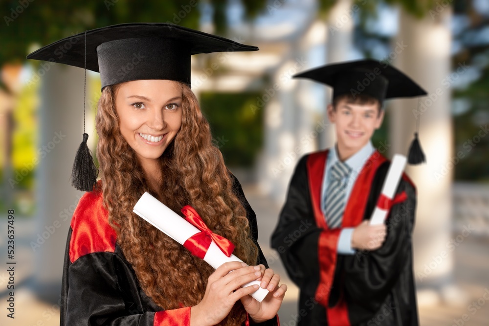 Happy young graduate student on the outdoor background