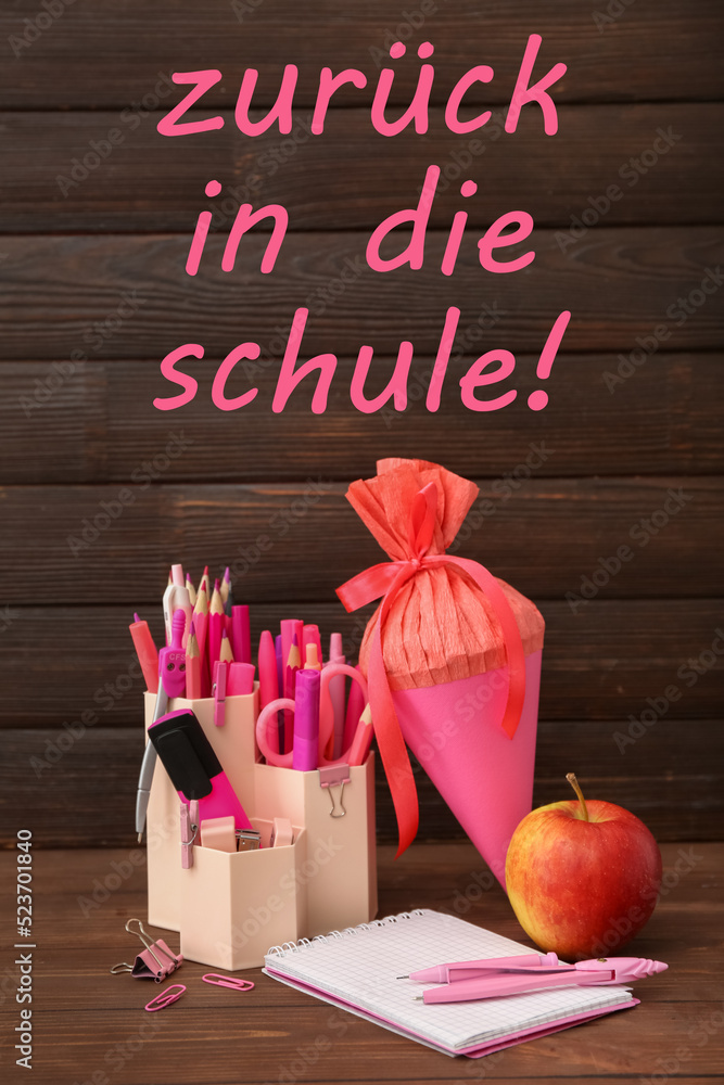 School cone, stationery and apple on wooden table. Zuruck in die schule (Back to school)