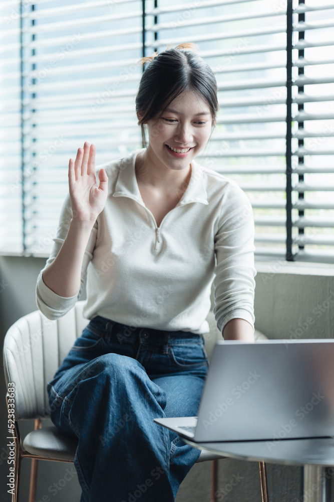 亚洲女人漂亮的年轻女人在办公室里用笔记本电脑工作。n在办公室里拿笔记本电脑工作