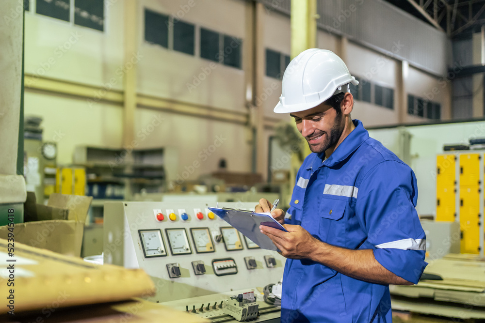 Young Caucasian male industrial worker working in manufacturing plant.