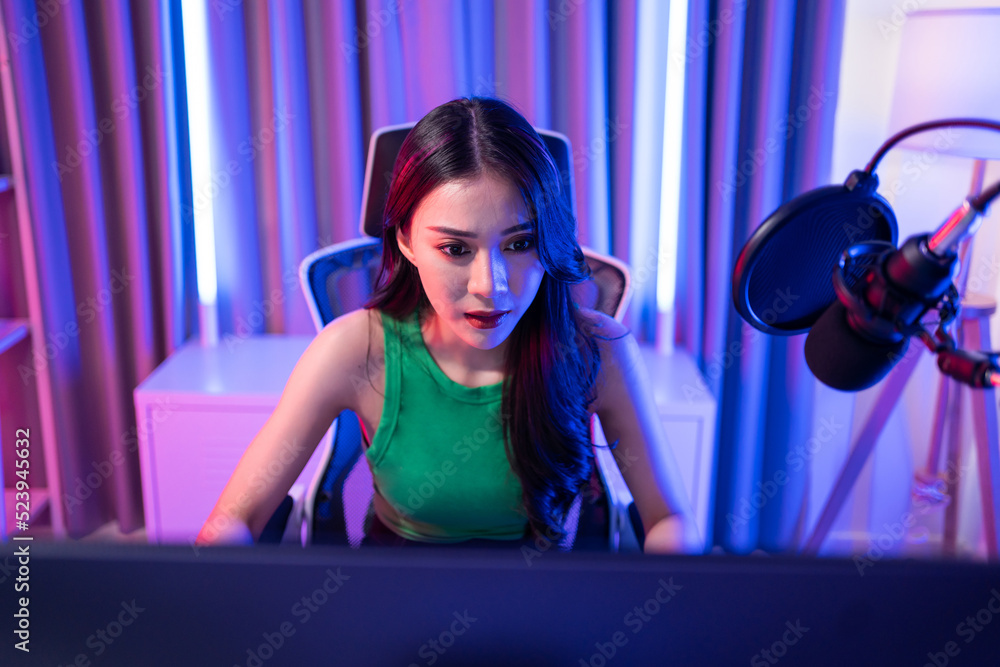 亚洲美女Esport女玩家在电脑上玩在线视频游戏。