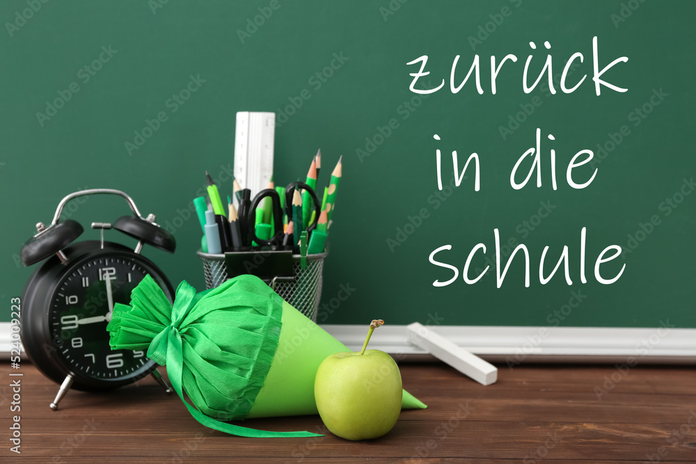 学校的圆锥体、苹果、时钟和文具放在教室的桌子上。学校里的Zuruck（返校）