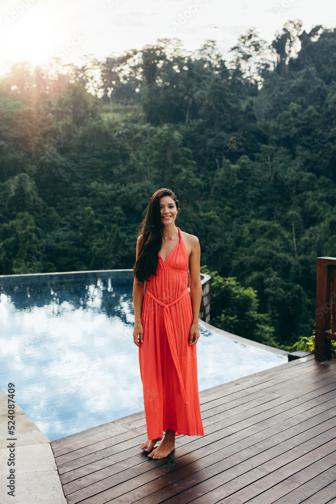 Attractive young woman standing near swimming pool