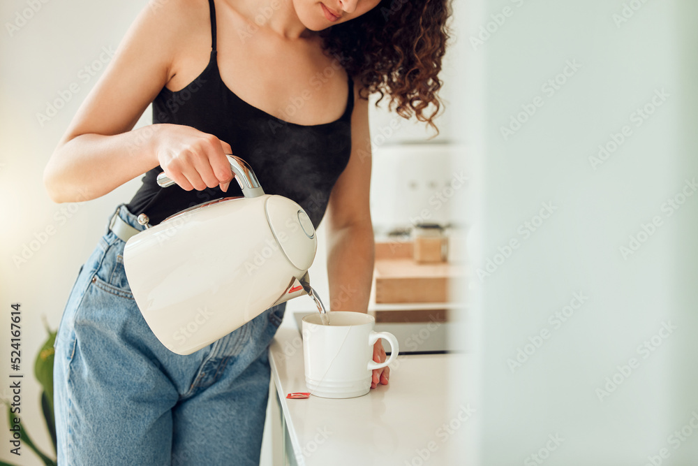 女人在家开始早上的早餐前泡了一杯茶。女人在尝试健康