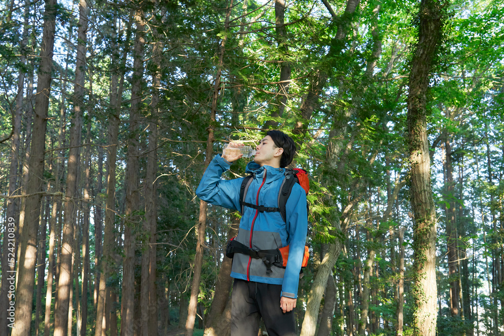 ペットボトルの水を飲んで水分補給する登山者