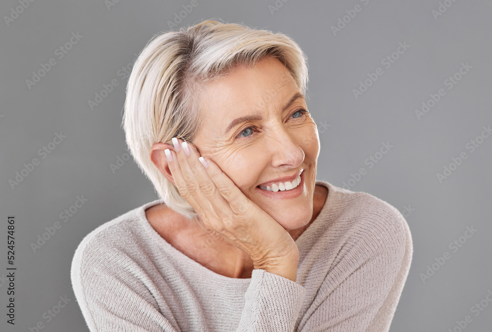 Thinking, idea and memory with a senior woman resting her head or chin on her hand in studio on a gr