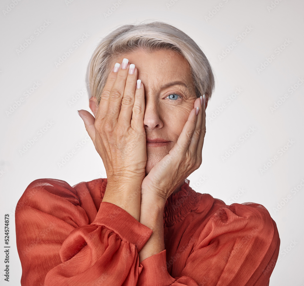 Beauty, health and wellness with a senior woman touching her face with her hands on a studio backgro