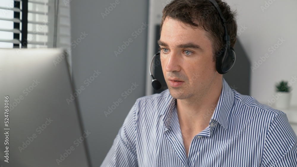 Competent male operator working with customers in the office. Concept of an operator, customer servi