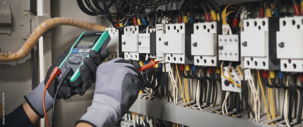 Electricity and electrical maintenance service, Engineer hand holding AC multimeter checking electri