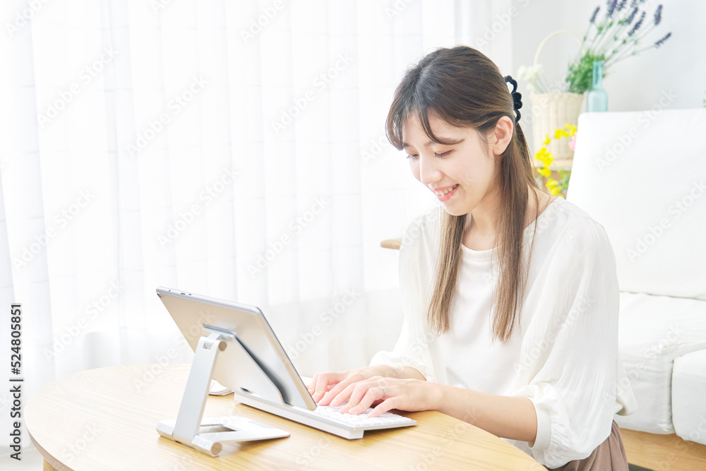 リビングでタブレットを使う女性