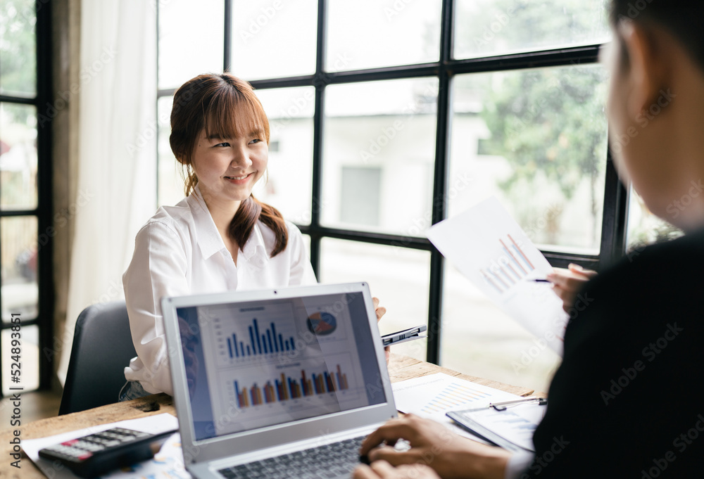 Asian business woman present and explain work to female colleague, using laptop computer in office, 