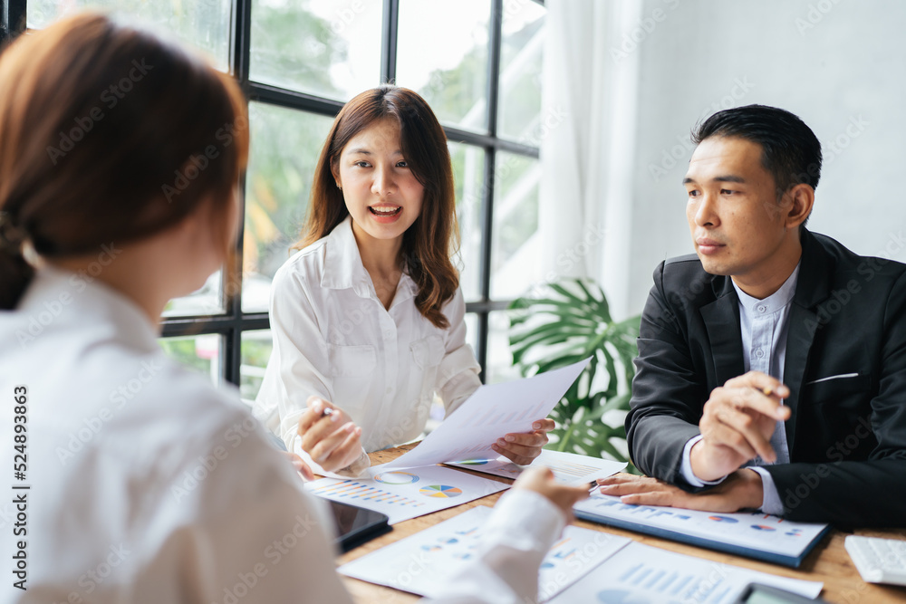 Asian business woman present and explain work to female colleague, using laptop computer in office, 