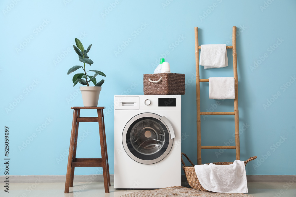 Interior of stylish laundry room with washing machine, stool and ladder