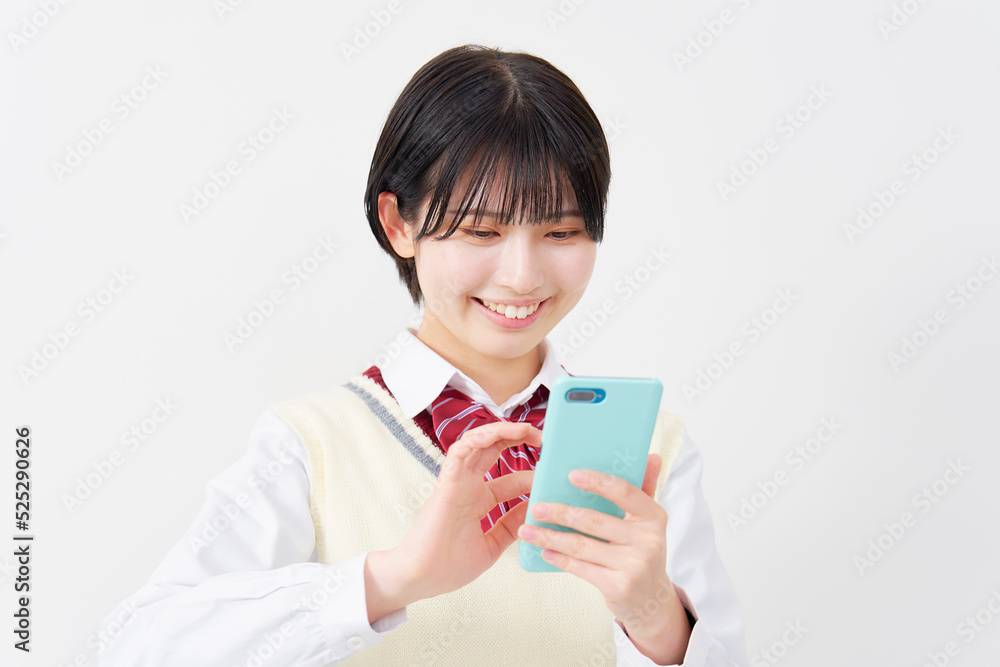 白背景でスマホを使う女子高生