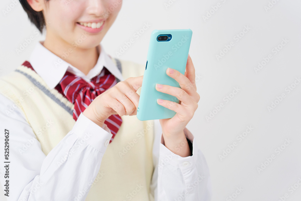 白背景でスマホを使う女子高生の手元