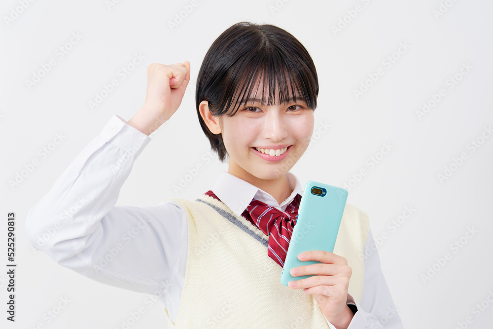 白背景でスマホを持ってガッツポーズする女子高生