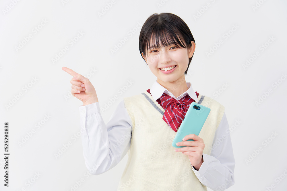 白背景でスマホを持って左を指差す女子高生