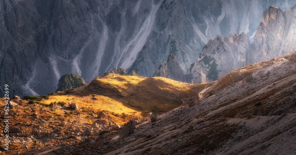 Mountain canyon lighted with bright sunbeam at sunset. Autumn in Dolomites alps, Italy. Landscape wi